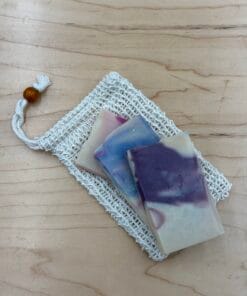 Three sample pieces of soap laying on a sisal soap saver.
